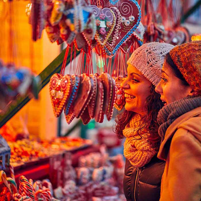 Två kvinnor som väljer julgodis på en julmarknad